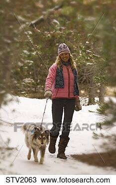 Stock Photo - a woman taking 
a walk through 
the woods on a 
snowy day with 
a dog. fotosearch 
- search stock 
photos, pictures, 
images, and photo 
clipart