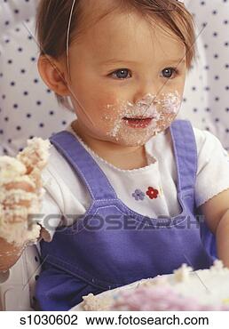 Stock Photo - girl (12-18 months)  at birthday party,  smeared with cake,  close-up. fotosearch  - search stock  photos, pictures,  images, and photo  clipart