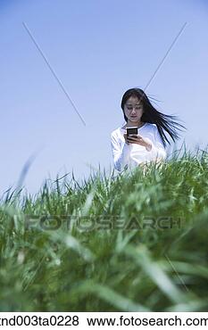 Stock Photo - a woman doing 
something with 
a pda. fotosearch 
- search stock 
photos, pictures, 
images, and photo 
clipart