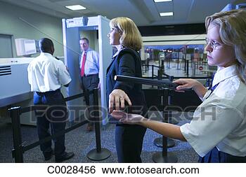 Stock Photo - an airport security 
officer uses a 
hand held metal 
detector to check. 
fotosearch - search 
stock photos, 
pictures, images, 
and photo clipart