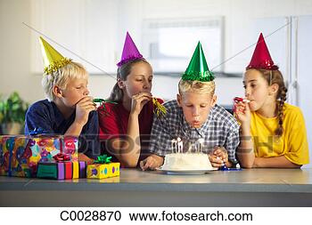 Stock Photography - a boy blows out 
candles on his 
birthday cake 
as his friends 
blow. fotosearch 
- search stock 
photos, pictures, 
images, and photo 
clipart