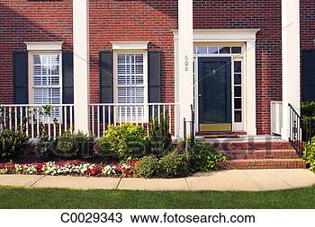 Stock Photo - close-up of a 
suburban brick 
home, front door, 
windows and sidewalk. 
fotosearch - search 
stock photos, 
pictures, images, 
and photo clipart