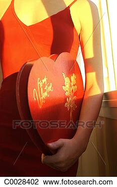 Stock Photo - close-up of a 
woman wearing 
a red dress and 
holding a large 
heart. fotosearch 
- search stock 
photos, pictures, 
images, and photo 
clipart