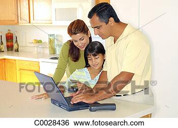 Stock Photo - a couple stands 
in the kitchen 
with their daughter 
using their credit. 
fotosearch - search 
stock photos, 
pictures, images, 
and photo clipart