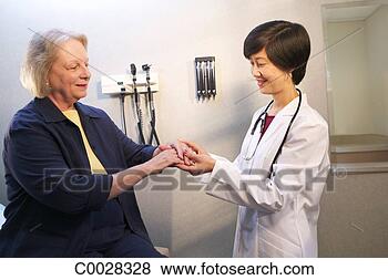 Stock Photo - a doctor examines 
a mature woman’s 
arm in the doctor’s 
office. fotosearch 
- search stock 
photos, pictures, 
images, and photo 
clipart