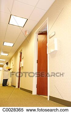 Stock Image - looking down the 
hall to a doctor 
standing outside 
of an exam room. 
fotosearch - search 
stock photos, 
pictures, images, 
and photo clipart