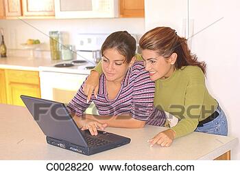 Stock Photography - a mother and daughter 
stand in the kitchen 
using a laptop 
computer. fotosearch 
- search stock 
photos, pictures, 
images, and photo 
clipart