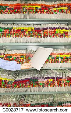Picture - an office worker 
holds a file folder 
in front of a 
wall of patient. 
fotosearch - search 
stock photos, 
pictures, images, 
and photo clipart