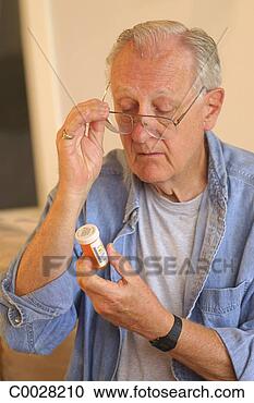 Stock Photography - portrait of a 
mature man holding 
his glasses as 
he reads the label 
on. fotosearch 
- search stock 
photos, pictures, 
images, and photo 
clipart