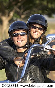 Stock Photo - portrait of a 
smiling biking 
couple wearing 
leather outfits, 
 helmets. fotosearch 
- search stock 
photos, pictures, 
images, and photo 
clipart