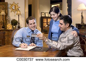 Picture - a couple purchases 
furniture,  passing 
their credit card 
to the. fotosearch 
- search stock 
photos, pictures, 
images, and photo 
clipart