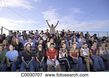 Picture - a crowd sits solemly 
in the stands 
as one boy in 
the middle jumps 
up. fotosearch 
- search stock 
photos, pictures, 
images, and photo 
clipart