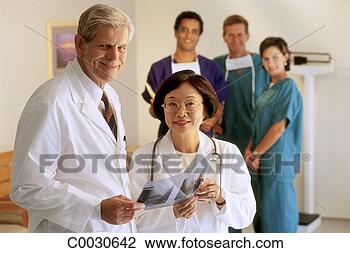 Stock Photo - portrait of doctors 
with the staff 
behind them in 
a doctor’s office. 
fotosearch - search 
stock photos, 
pictures, images, 
and photo clipart