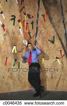 Stock Image - businessman talking 
on a cellphone 
near an indoor 
rock climbing 
wall. fotosearch 
- search stock 
photos, pictures, 
images, and photo 
clipart