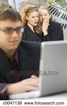 Stock Photo - businessman working 
while colleagues 
whisper. fotosearch 
- search stock 
photos, pictures, 
images, and photo 
clipart