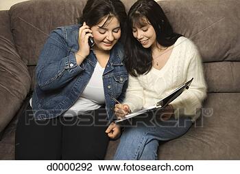 Stock Photo - couple on couch 
using cell phone 
and appointment 
book. fotosearch 
- search stock 
photos, pictures, 
images, and photo 
clipart