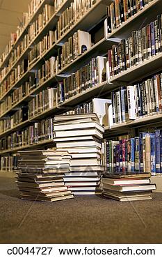 Picture - books piled on 
floor next to 
library bookshelves. 
fotosearch - search 
stock photos, 
pictures, images, 
and photo clipart