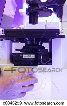Stock Photograph - hand adjusting 
a button on a 
microscope. fotosearch 
- search stock 
photos, pictures, 
images, and photo 
clipart