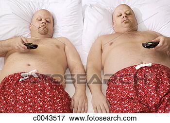 Picture - identical twins 
relaxing in bed 
with remote controls. 
fotosearch - search 
stock photos, 
pictures, images, 
and photo clipart