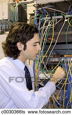 Stock Photo - a young businessman 
checks connectivity 
on a computer 
server rack. fotosearch 
- search stock 
photos, pictures, 
images, and photo 
clipart