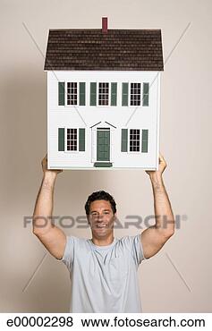 Stock Photo - man holding miniature 
house. fotosearch 
- search stock 
photos, pictures, 
images, and photo 
clipart