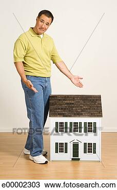 Stock Photo - man standing near 
miniature house. 
fotosearch - search 
stock photos, 
pictures, images, 
and photo clipart