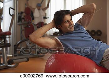 Stock Photograph - man exercising 
on exercise ball 
in gym. fotosearch 
- search stock 
photos, pictures, 
images, and photo 
clipart