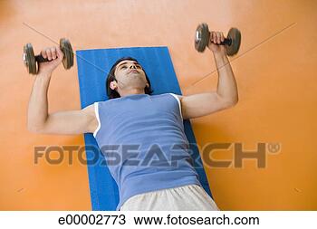 Stock Photo - man lifting dumbbells 
and lying on exercise 
mat. fotosearch 
- search stock 
photos, pictures, 
images, and photo 
clipart