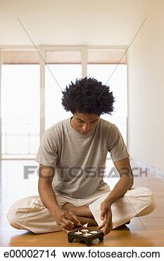 Stock Photo - man lighting meditation 
candles. fotosearch 
- search stock 
photos, pictures, 
images, and photo 
clipart