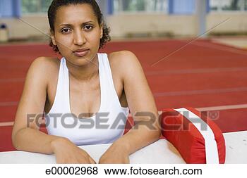 Stock Photo - young woman sitting 
in gym. fotosearch 
- search stock 
photos, pictures, 
images, and photo 
clipart
