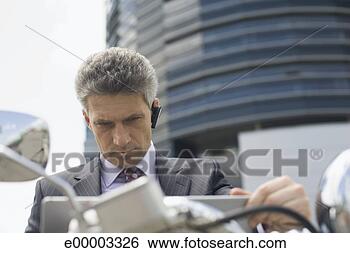 Stock Photo - businessman using 
laptop on motor 
scooter. fotosearch 
- search stock 
photos, pictures, 
images, and photo 
clipart
