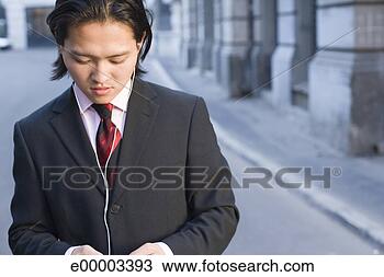 Stock Photo - man in business 
attire listening 
to earphones. 
fotosearch - search 
stock photos, 
pictures, images, 
and photo clipart