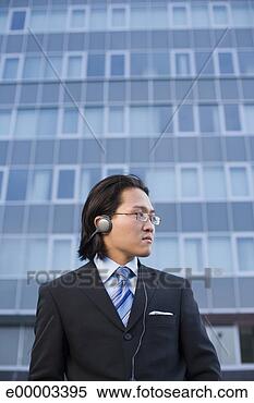 Stock Image - man in business 
attire listening 
to headphones. 
fotosearch - search 
stock photos, 
pictures, images, 
and photo clipart