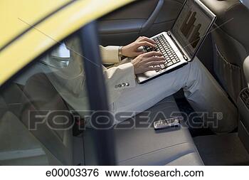 Stock Photo - woman in business 
attire using laptop 
in backseat of 
vehicle. fotosearch 
- search stock 
photos, pictures, 
images, and photo 
clipart