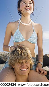 Stock Photo - man carrying woman 
on his shoulders 
on beach. fotosearch 
- search stock 
photos, pictures, 
images, and photo 
clipart