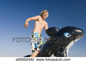 Stock Photo - man riding whale 
float on beach. 
fotosearch - search 
stock photos, 
pictures, images, 
and photo clipart