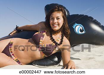 Picture - woman in bikini 
lying on beach 
with whale float. 
fotosearch - search 
stock photos, 
pictures, images, 
and photo clipart