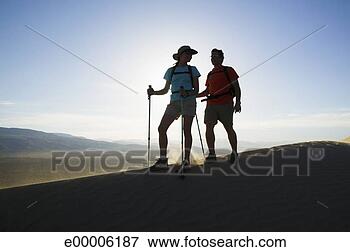 Picture - backpackers hiking 
across desert 
sand dune. fotosearch 
- search stock 
photos, pictures, 
images, and photo 
clipart