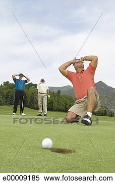 Stock Image - golf ball on edge 
of hole and frustrated 
golfers. fotosearch 
- search stock 
photos, pictures, 
images, and photo 
clipart