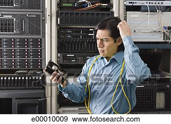 Stock Photograph - confused tech 
support worker 
with hard drive. 
fotosearch - search 
stock photos, 
pictures, images, 
and photo clipart