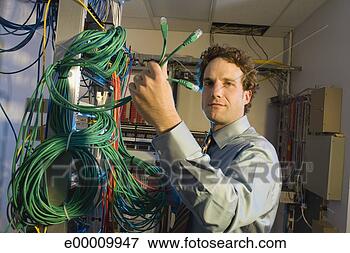 Picture - man with cords 
in server room. 
fotosearch - search 
stock photos, 
pictures, images, 
and photo clipart