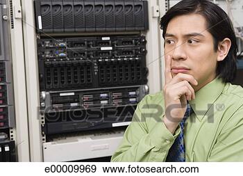 Stock Photograph - man thinking in 
server room. fotosearch 
- search stock 
photos, pictures, 
images, and photo 
clipart