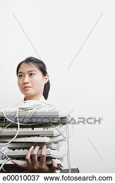 Foto - mulher,  segurando, 
 pilha,  computador, 
 teclados. fotosearch 
- busca de fotos, 
imagens e clipart