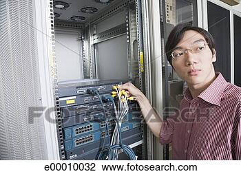 Stock Photo - technician connecting 
computer cables. 
fotosearch - search 
stock photos, 
pictures, images, 
and photo clipart