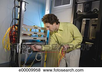 Stock Photo - worker connecting 
cable in server 
room. fotosearch 
- search stock 
photos, pictures, 
images, and photo 
clipart