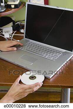 Banco de Imagem - mão,  inserindo, 
 disco,  laptop, 
 computador. fotosearch 
- busca de fotos, 
imagens e clipart