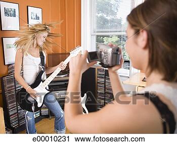 Arquivo de Fotografia - mulheres,  tocando, 
 guitarra,  filmando, 
 desempenho. fotosearch 
- busca de fotos, 
imagens e clipart