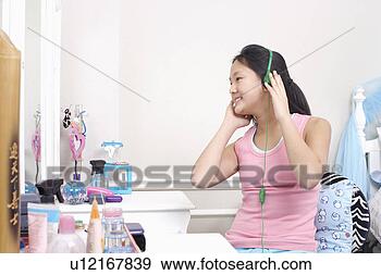 Arquivo Fotográficos - menina,  desgastar, 
 fones,  escutar, 
 música. fotosearch 
- busca de fotos, 
imagens e clipart