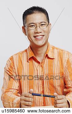 Arquivo de Fotografias - retrato,  meio, 
 adulto,  homem, 
 segurando,  caneta, 
 sorrindo. fotosearch 
- busca de fotos, 
imagens e clipart