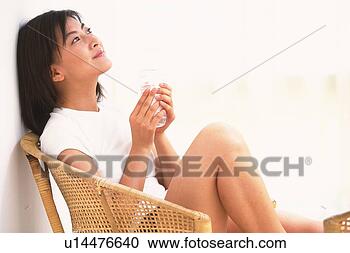 Stock Photography - woman holding 
a plastic bottle, 
sitting down on 
chair. fotosearch 
- search stock 
photos, pictures, 
images, and photo 
clipart